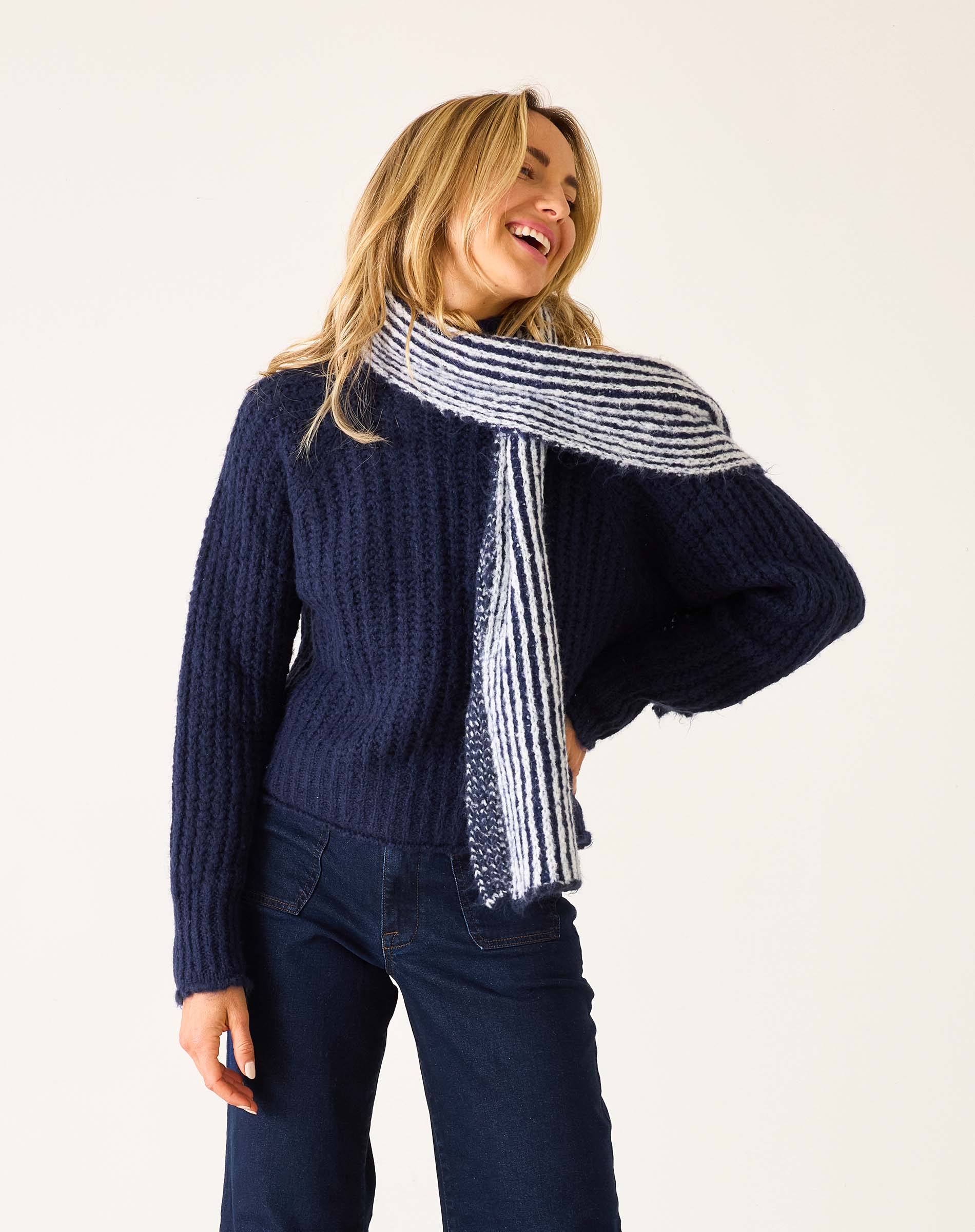 Navy blue ribbed knit sweater with a matching striped shawl draped over the shoulders.