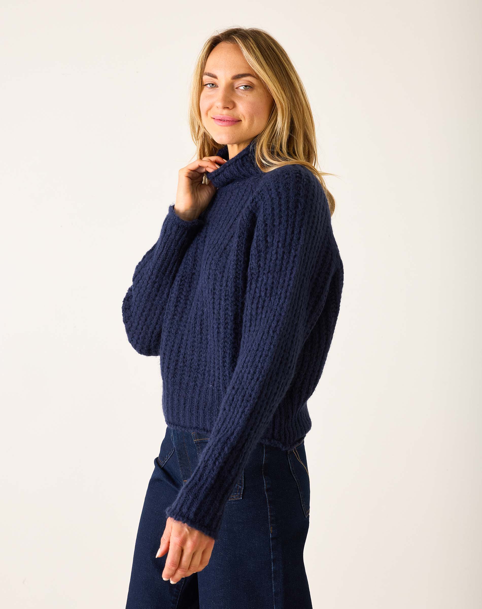 Navy blue ribbed knit sweater with a high turtleneck and long sleeves.