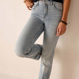Person wearing light blue jeans on a plain background