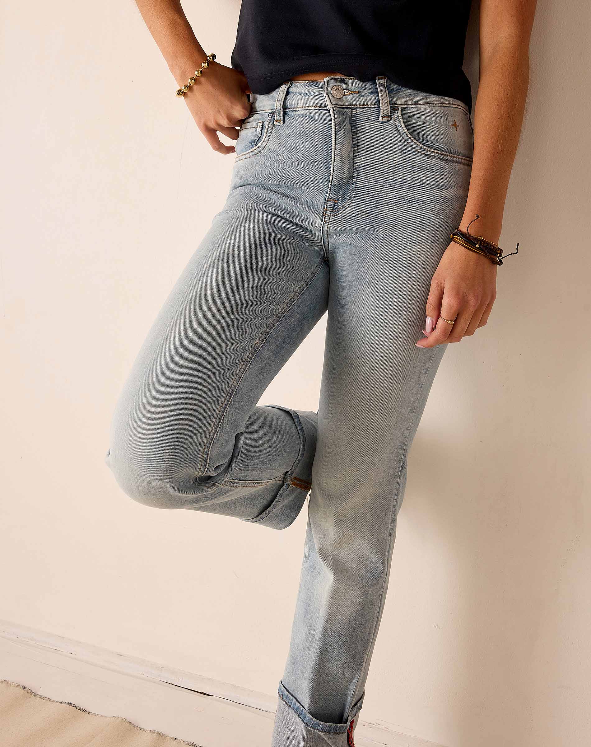 Person wearing light blue jeans on a plain background