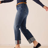 Faded indigo straight-leg denim pants with rolled hems and a decorative red stripe.