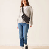 MERSEA ladies' travel-ready faded ink straight leg jeans paired with a grey knit top and black crossbody bag.