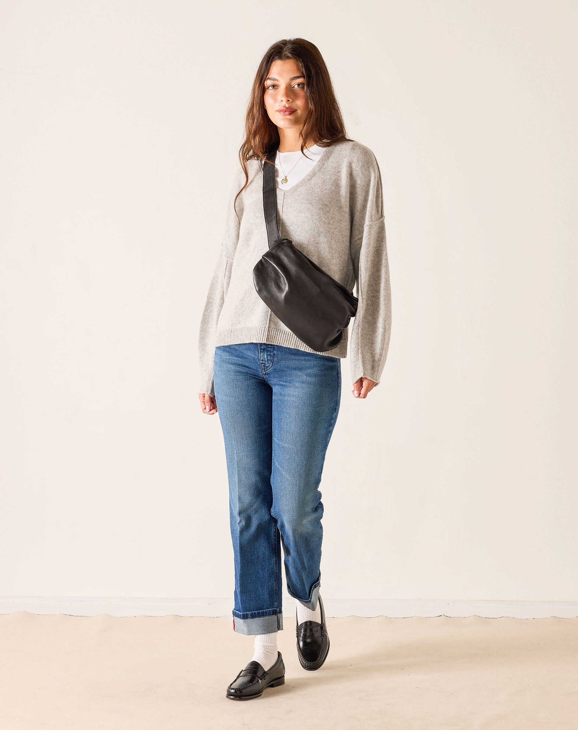 MERSEA ladies' travel-ready faded ink straight leg jeans paired with a grey knit top and black crossbody bag.