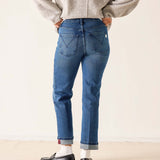 Back view of women's travel-friendly faded ink blue straight-leg jeans with a cuffed hem.