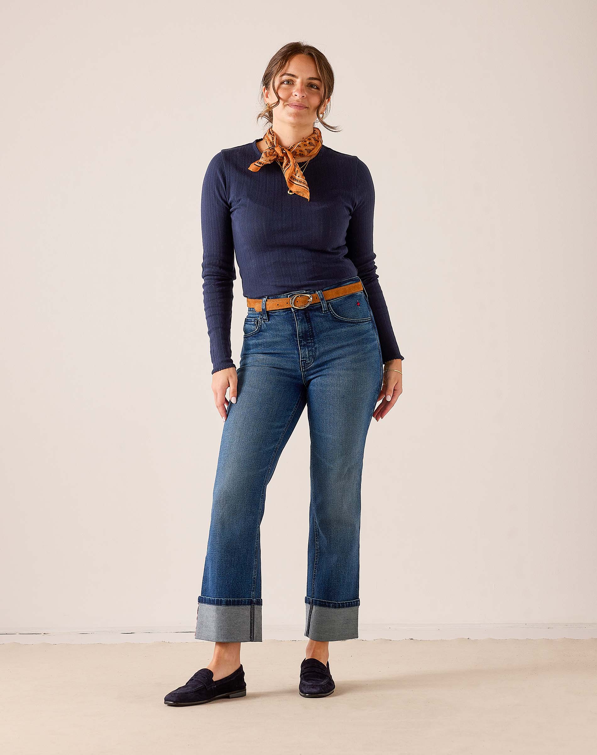 Faded ink straight leg denim jeans with cuffed hems and a matching belt.