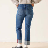 Person wearing blue jeans and a gray sweater on a plain background