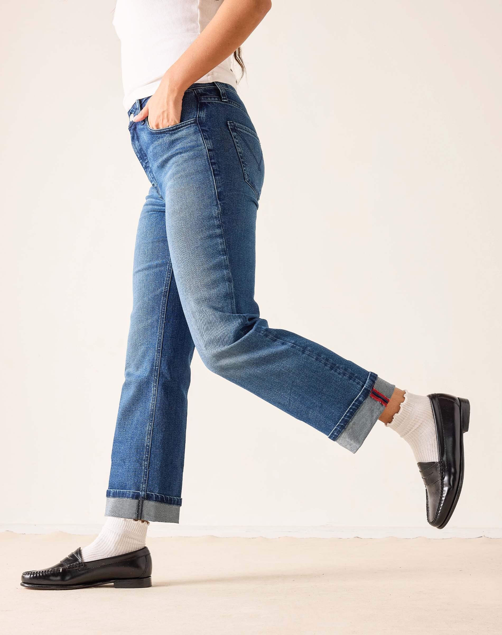 Faded ink straight leg denim jeans with a cuffed hem and distressed details.