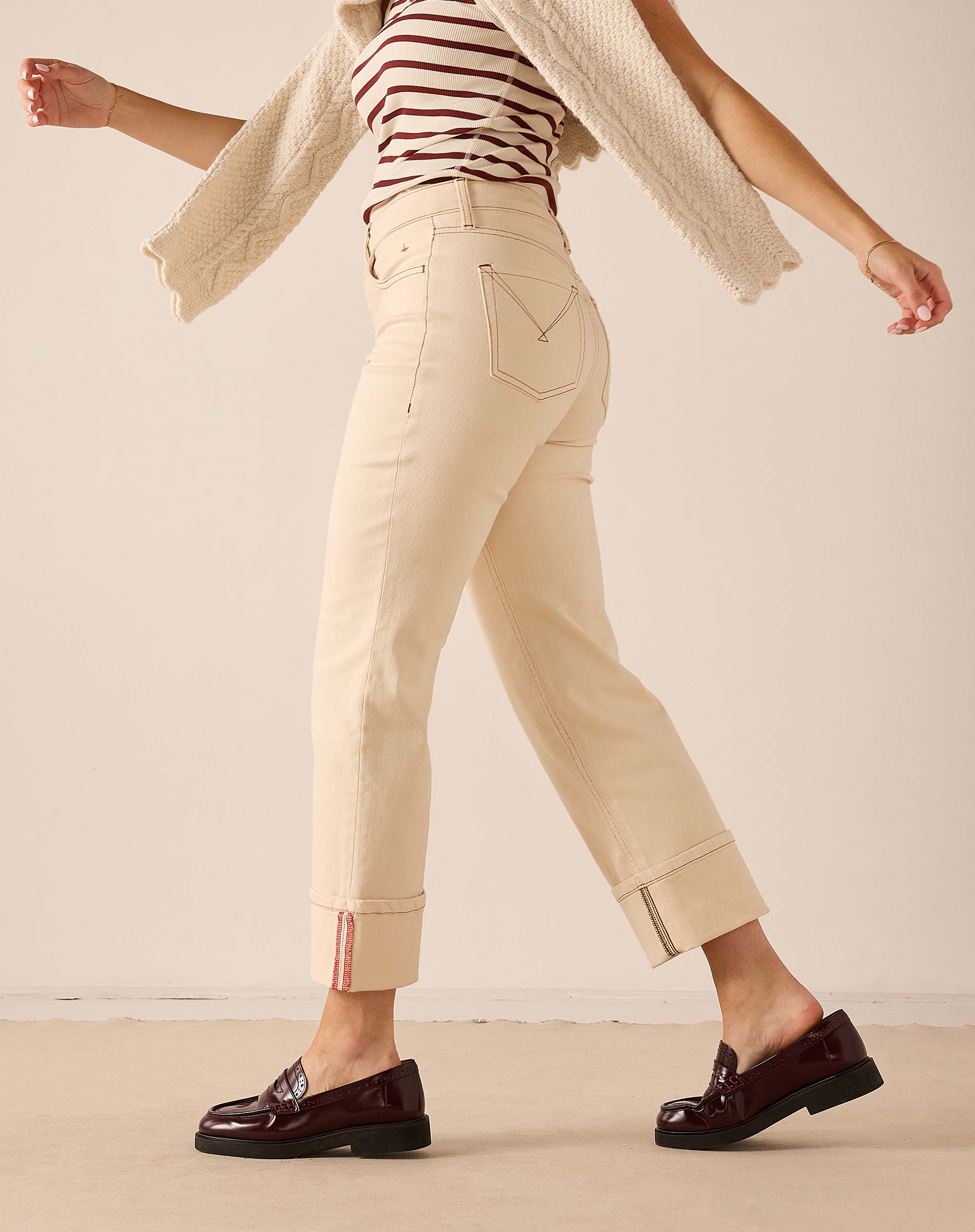 Oat colored straight leg pants in a soft cotton blend with contrast stitching and decorative hem details.