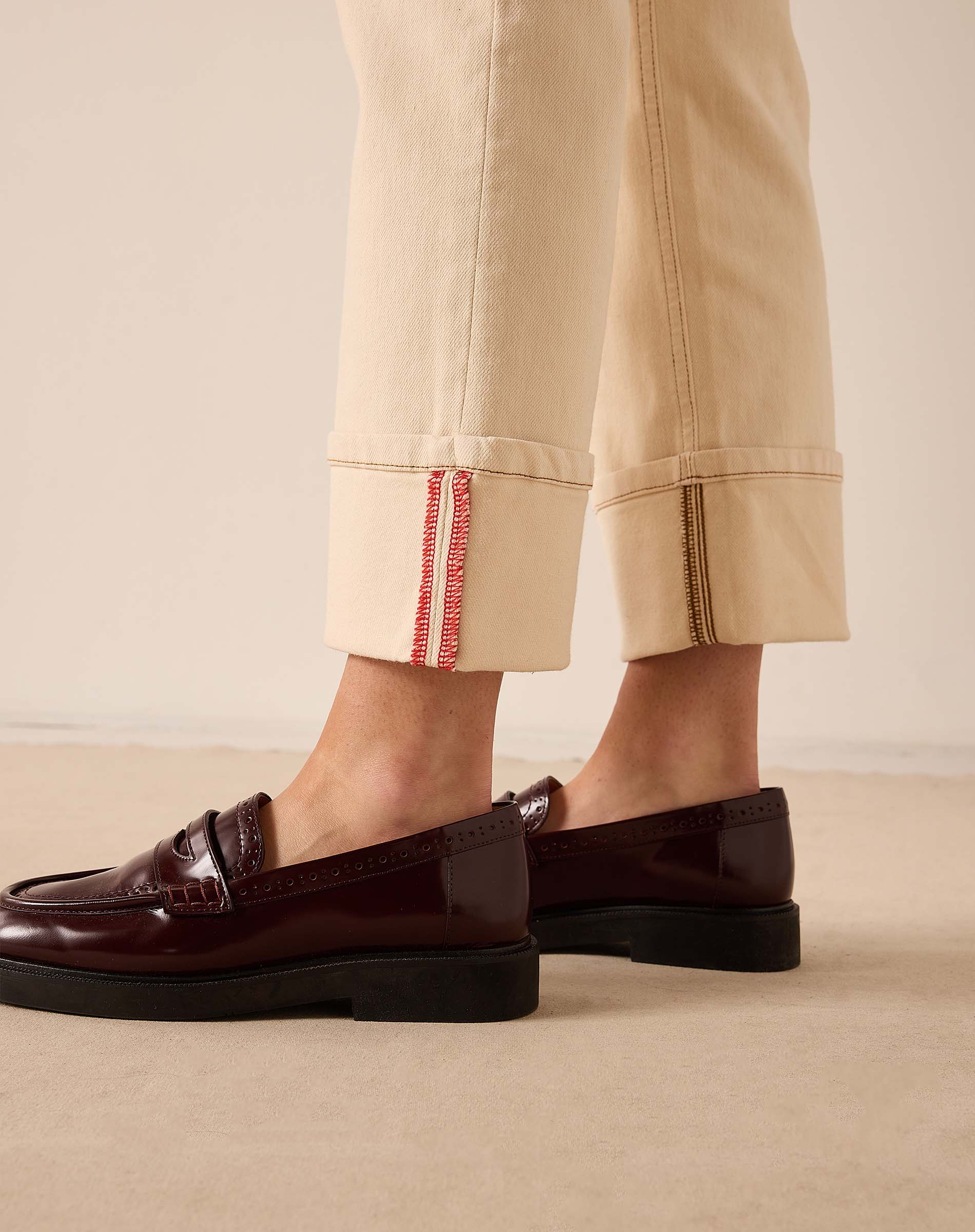 Oat-colored straight leg pants with a decorative cuff and seam detail