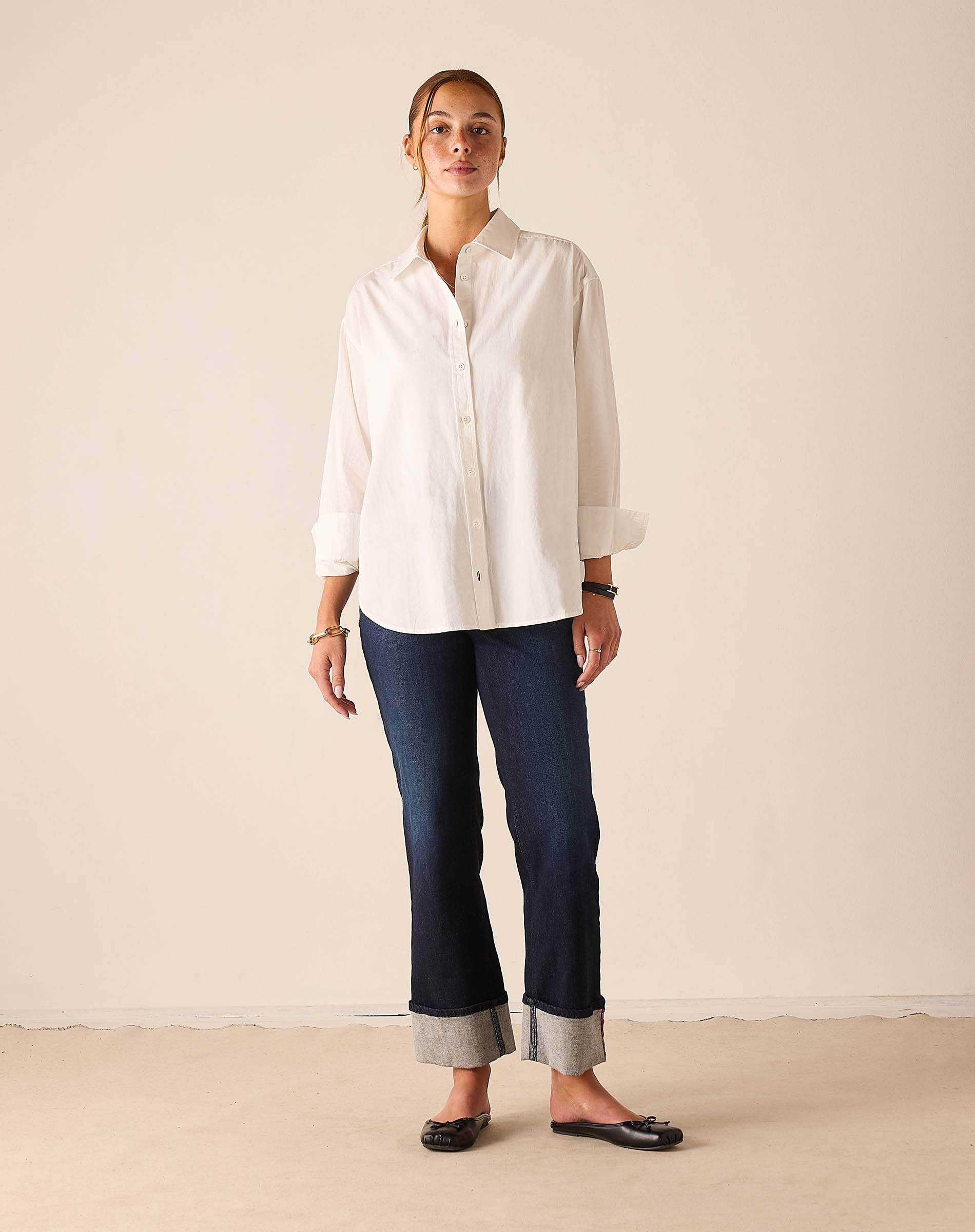 Women's travel-friendly navy blue rinse denim straight-leg pants with cuffed hems.