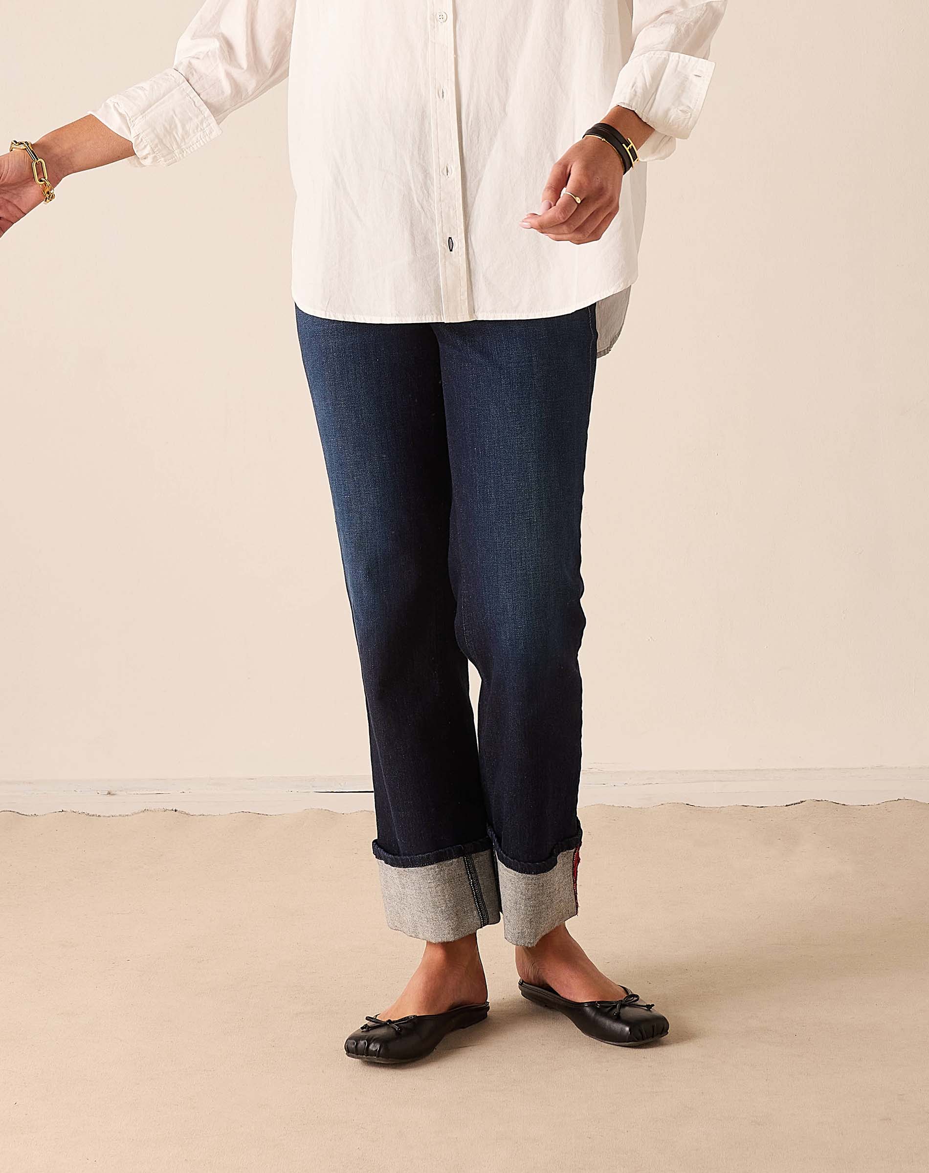 Dark blue straight-leg denim pants with cuffed hems.