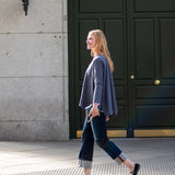 Charcoal grey oversized knit top and navy blue straight-leg pants with textured hems.