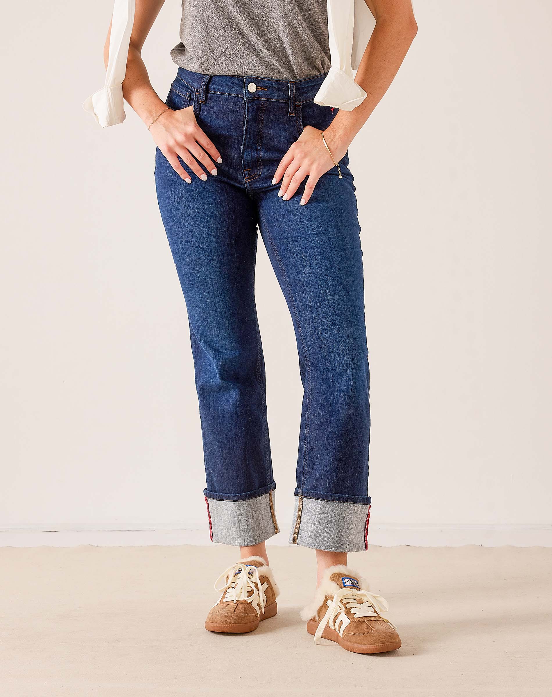 Mid-wash blue denim straight-leg jeans with contrast red stitching and cuffed hems.