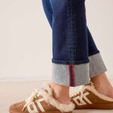 Rinse blue straight-leg denim jeans with cuffed hems and cozy cream-colored shearling-lined slippers.