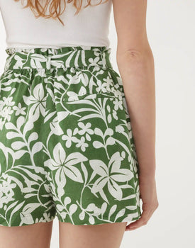 female wearing green with white florals pull-on linen short with self belt backwards on a white background