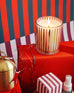lit mersea cider by the sea holiday boxed candle on top of wrapped box with brass candle 
