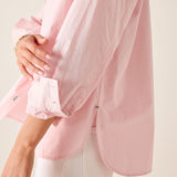 Close-up of a person wearing a light pink shirt with a blurred background