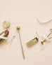 collection of several brass candle items laying on a white background with white ribbon