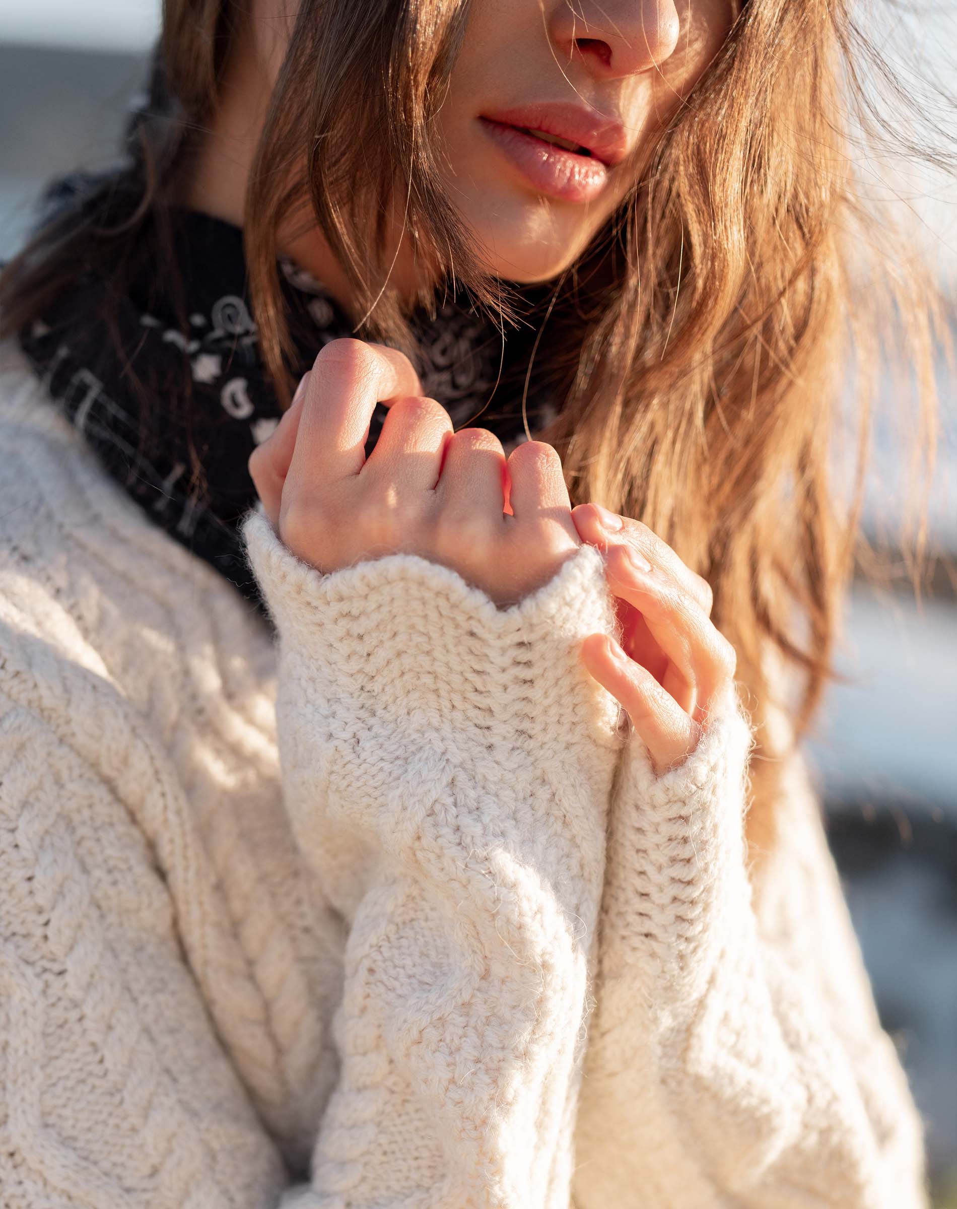 Cream cable knit sweater with chunky texture and long sleeves.