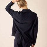 Back view of women's travel-friendly navy blue relaxed fit cotton boyfriend jacket with topstitching detail.