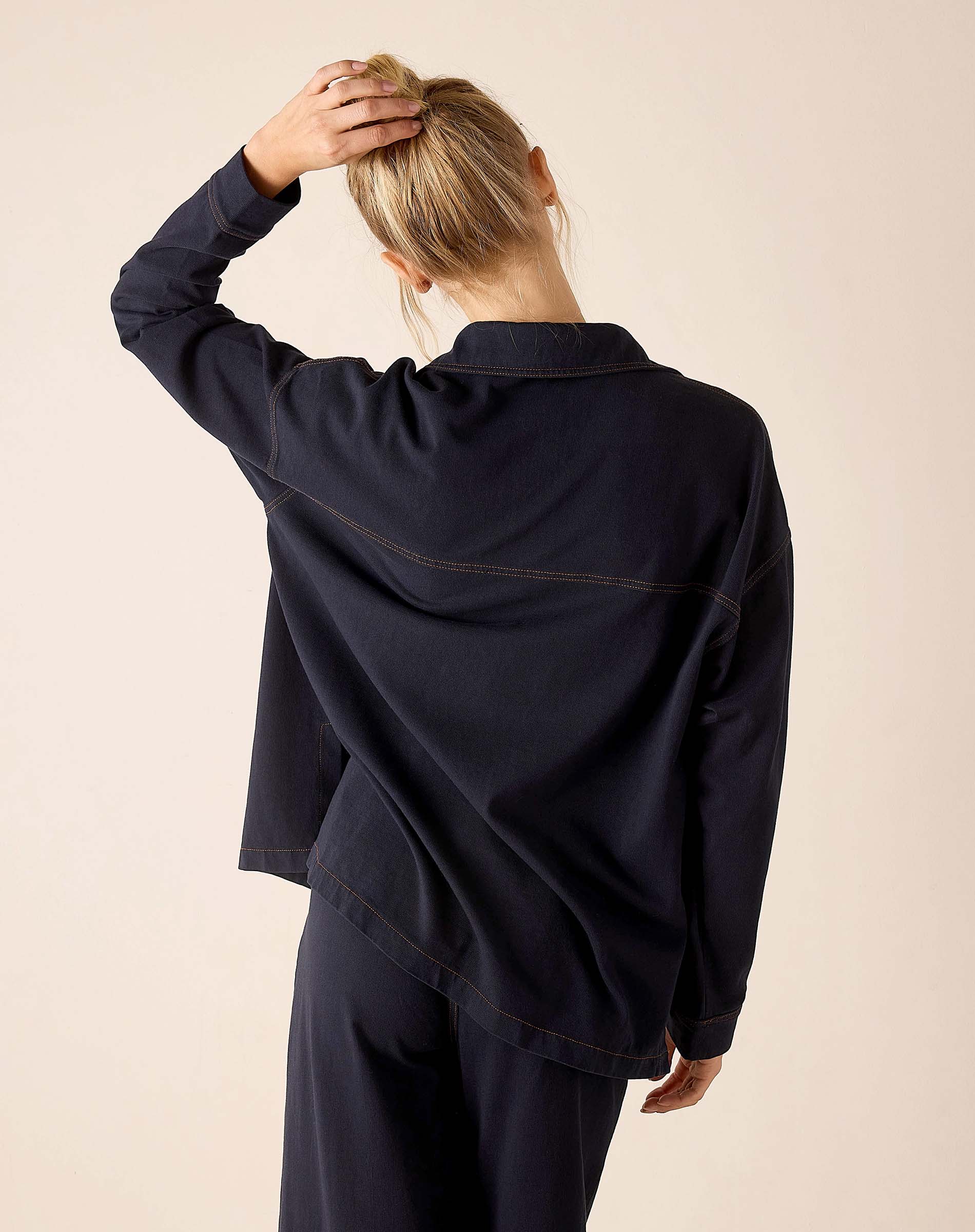 Back view of women's travel-friendly navy blue relaxed fit cotton boyfriend jacket with topstitching detail.