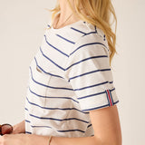 Person wearing a white and blue striped shirt with a red and blue trim on a plain background