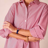 Cardinal red and white pinstripe button-up shirt featuring a relaxed fit and long sleeves with rolled cuffs.