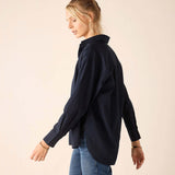 Woman wearing a navy shirt and blue jeans on a beige background