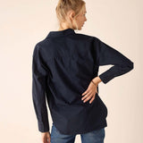 Person wearing a navy blue shirt and blue jeans on a beige background