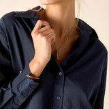 Person wearing a navy blue shirt with a neutral background