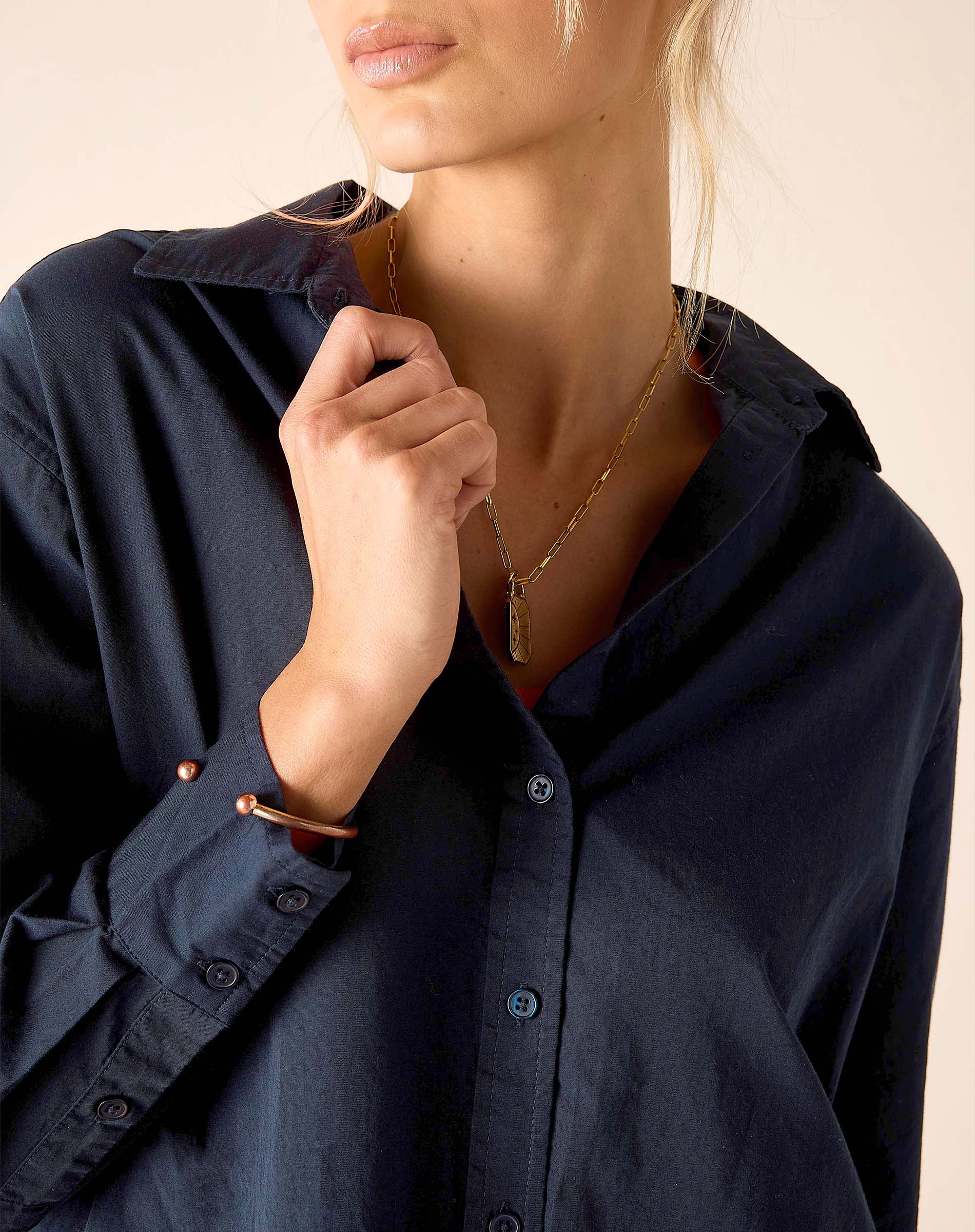 Person wearing a navy blue shirt with a neutral background