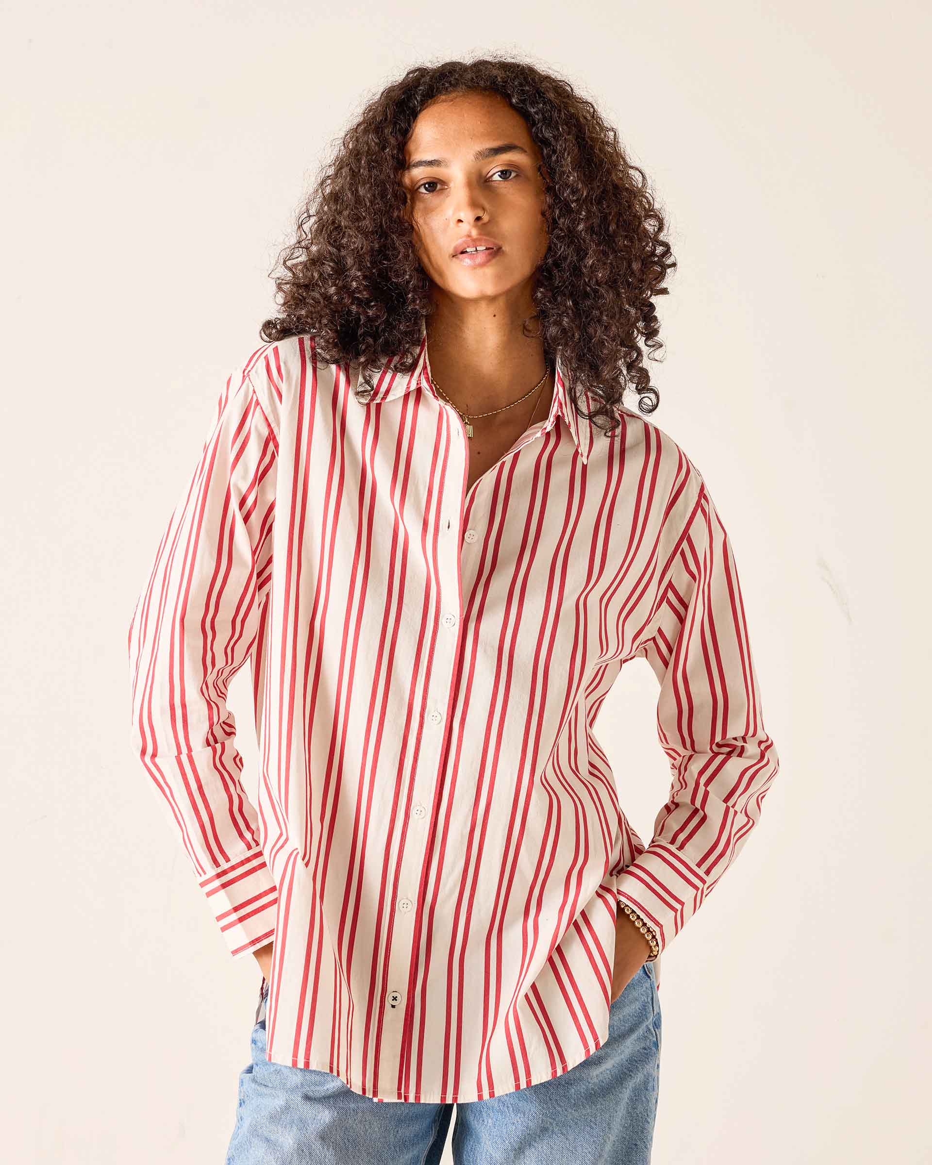 Woman wearing a red and white striped shirt against a plain background