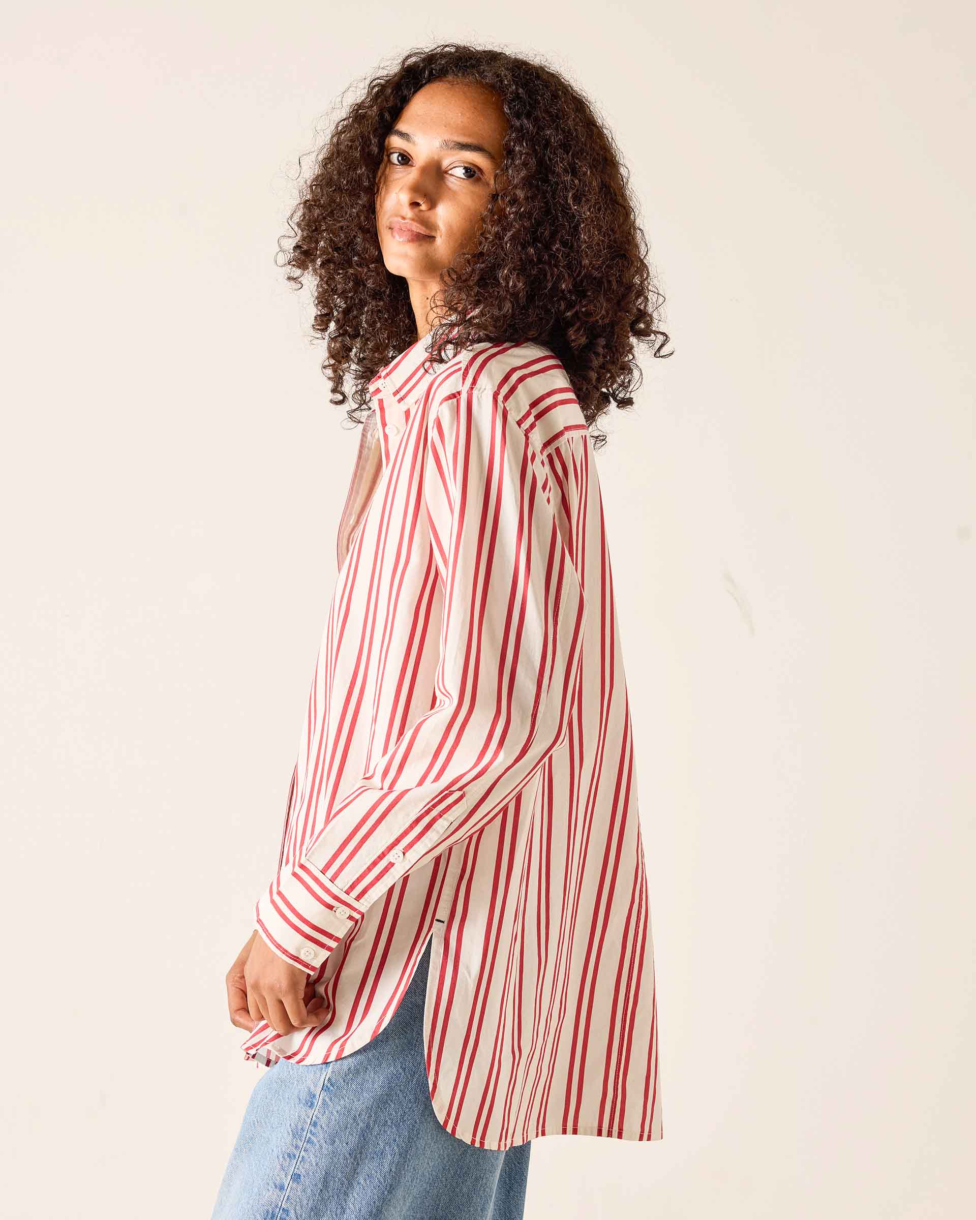 Person wearing a red and white striped shirt against a plain background