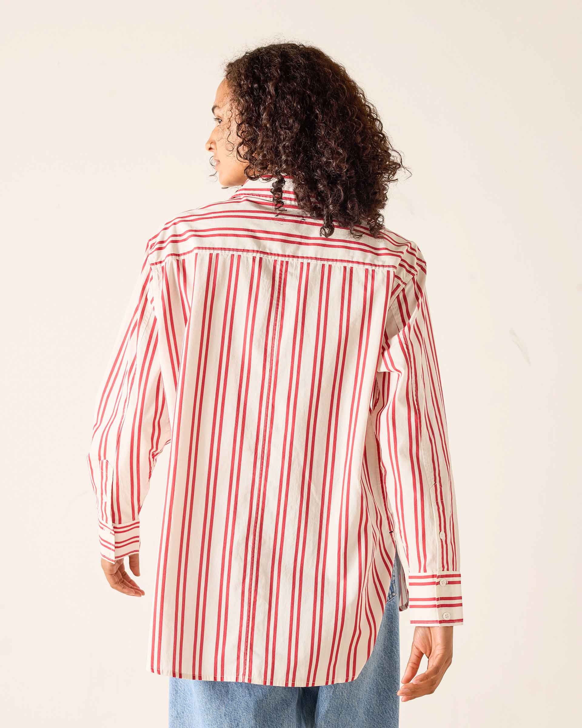 Person wearing a red and white striped shirt against a plain background