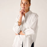 White relaxed-fit button-up linen shirt with rolled sleeves and side slits