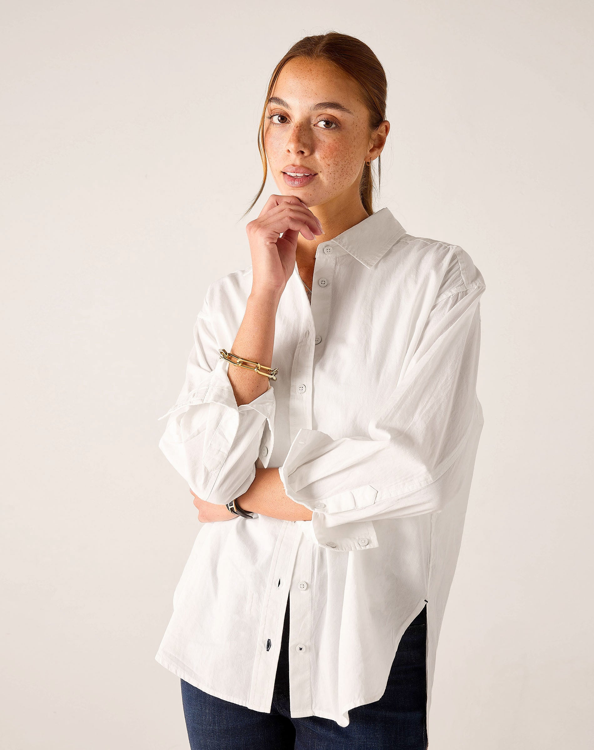 White relaxed-fit button-up linen shirt with rolled sleeves and side slits