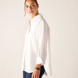 White oversized button-up linen shirt with wide sleeves and a curved hem.