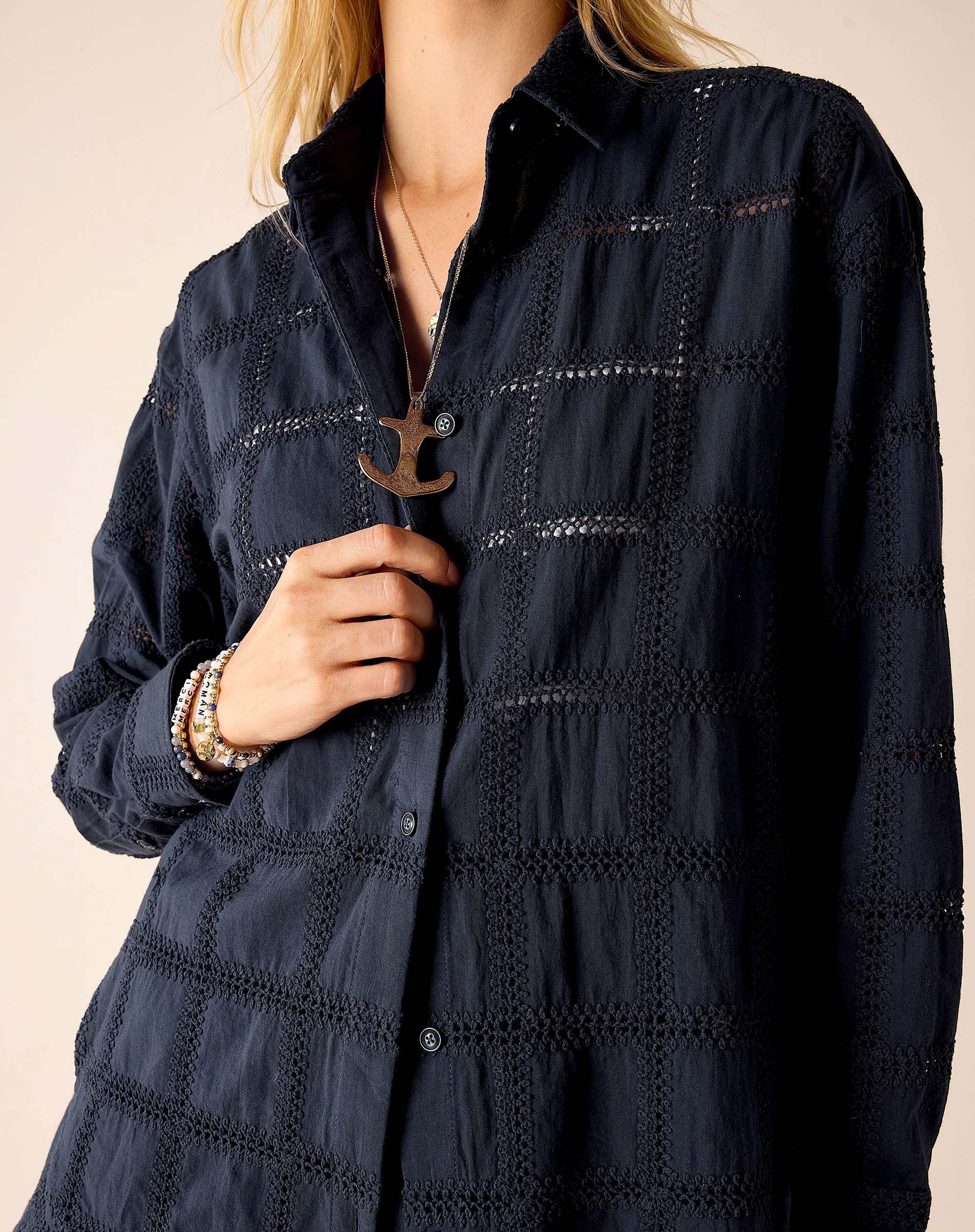 Navy blue textured shirt worn by a person on a beige background