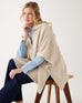 woman wearing mersea cambridge collar poncho in oatmeal beige sitting on chair