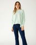woman wearing mersea camden mockneck sweater in caribbean sea green