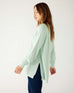 profile of woman wearing mersea camden mockneck sweater in caribbean sea green