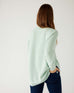 rear view of woman wearing mersea camden mockneck sweater in caribbean sea green