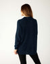 rear view of woman wearing mersea camden mockneck sweater in navy and sea salt trim