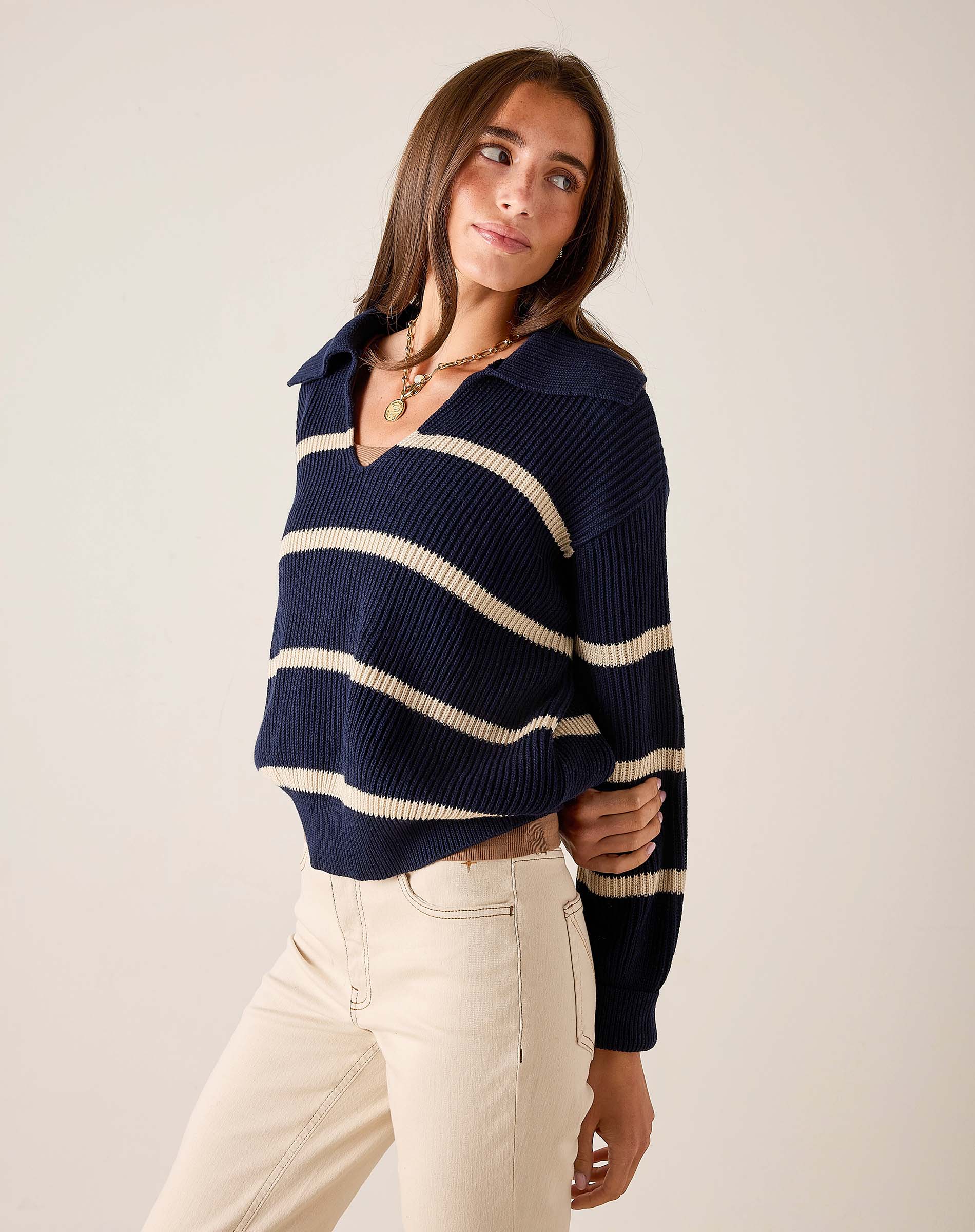 Navy and cream striped knit sweater with a boat neck and long sleeves.