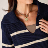 Navy and cream striped knit sweater with a wide boatneck and ribbed texture.
