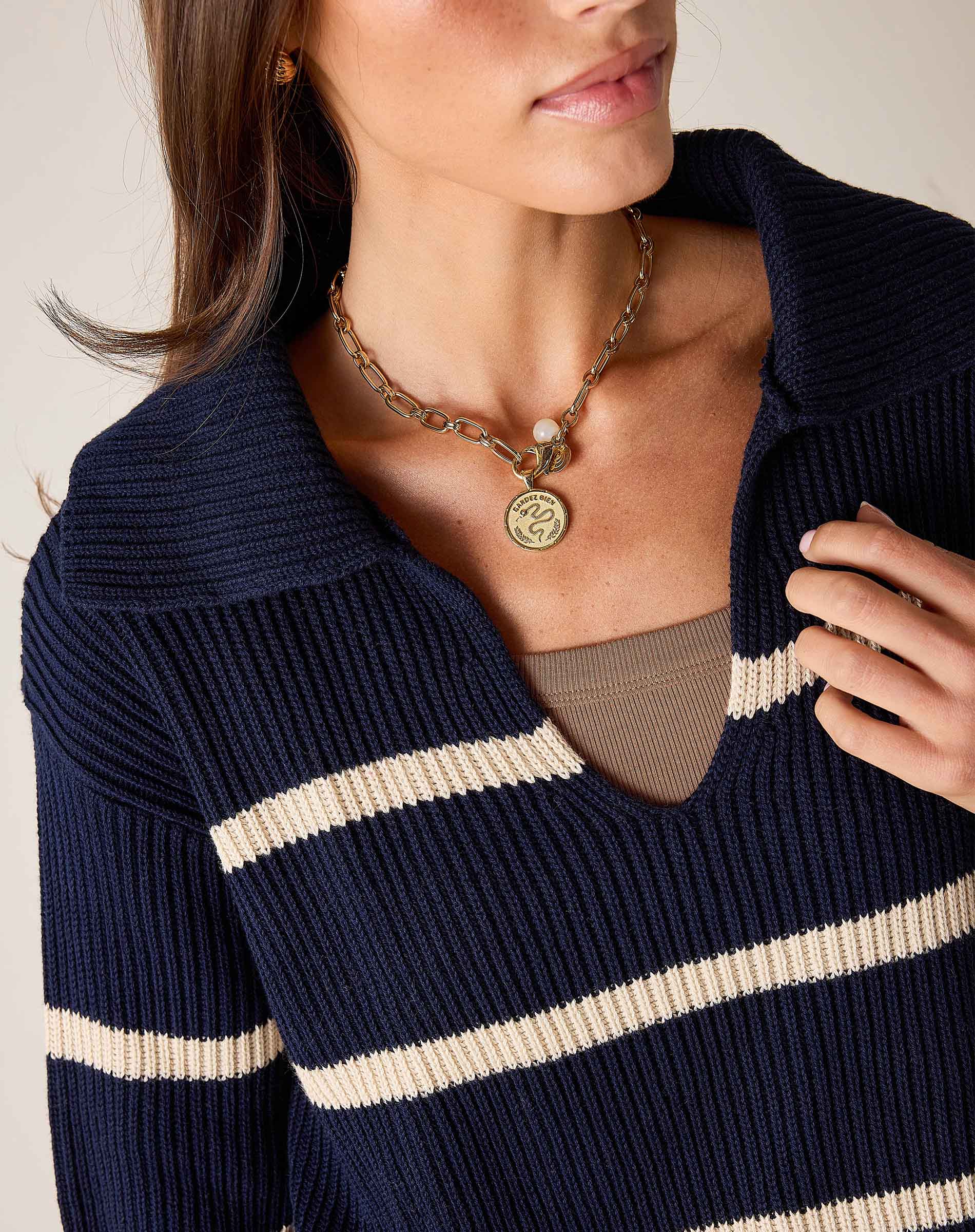 Navy and cream striped knit sweater with a wide boatneck and ribbed texture.