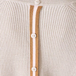 Close-up of a beige knit cardigan with button details