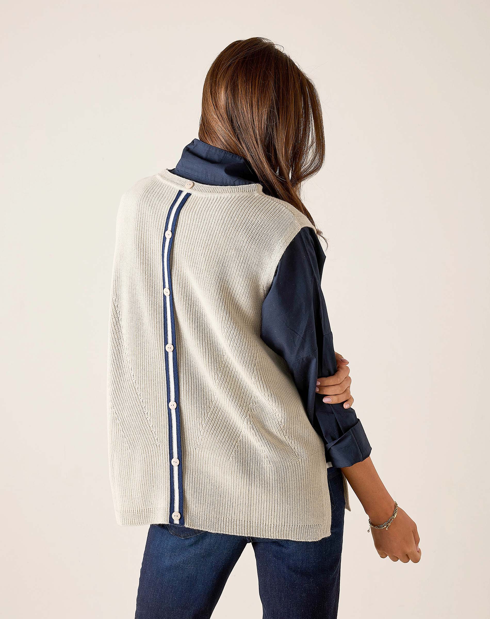 Side view of women's travel-friendly desert palm knit vest with a buttoned side seam and navy blue accents.