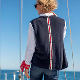 Back view of women's travel-friendly navy knit vest with buttoned red and white stripe detail.