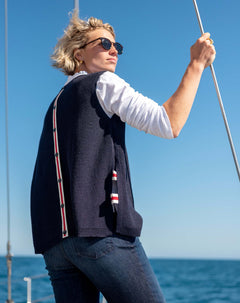 Side view of the navy knit vest with red and white stripe detail.